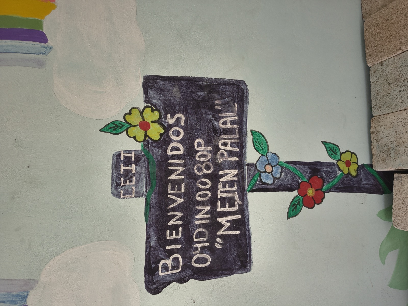 Mural de bienvenida en Pakchen con palabras en español y maya